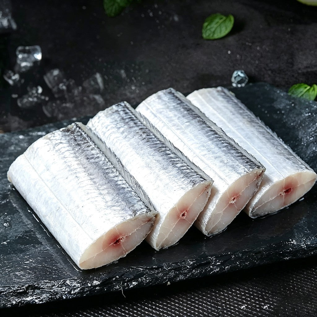 Row of raw frozen beltfish mid-cut segments on dark slate